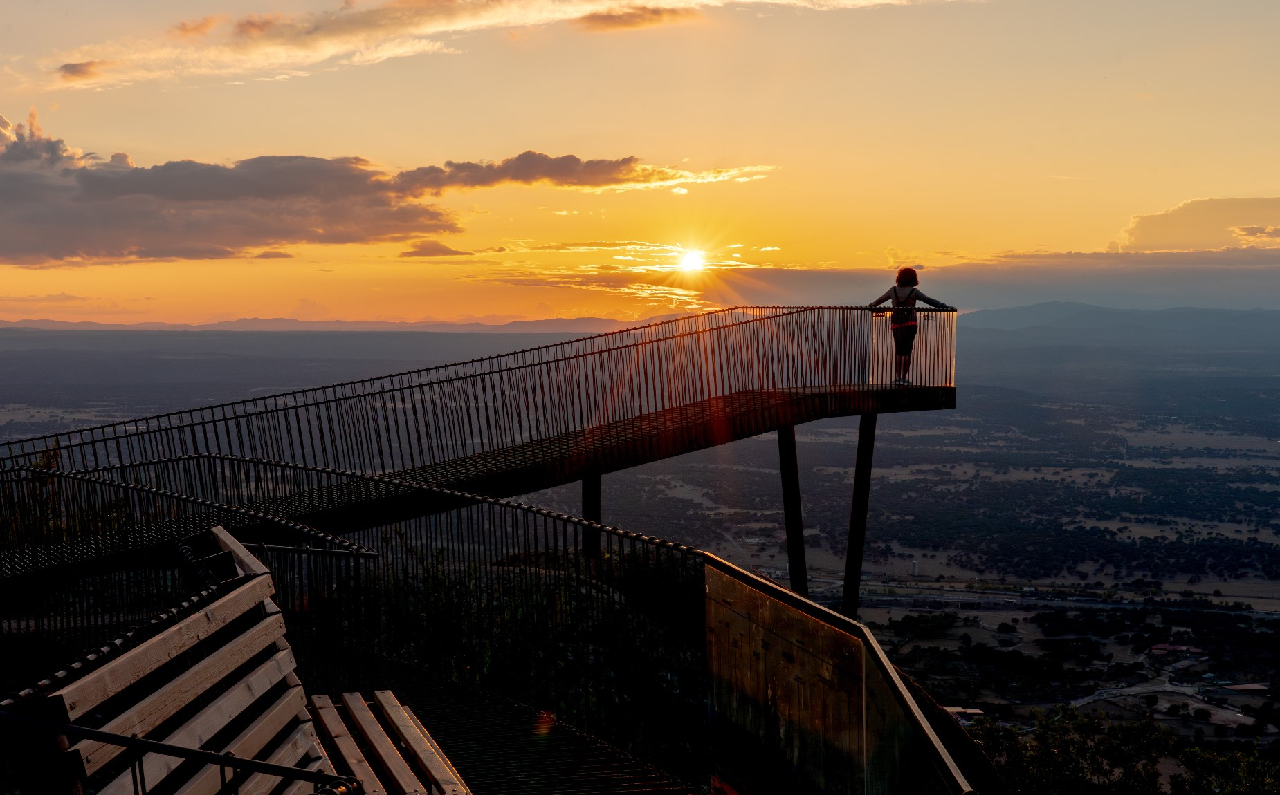 Maravillosa imagen de una persona subida a lo m&aacute;s alto del mirador contemplando la puesta de sol