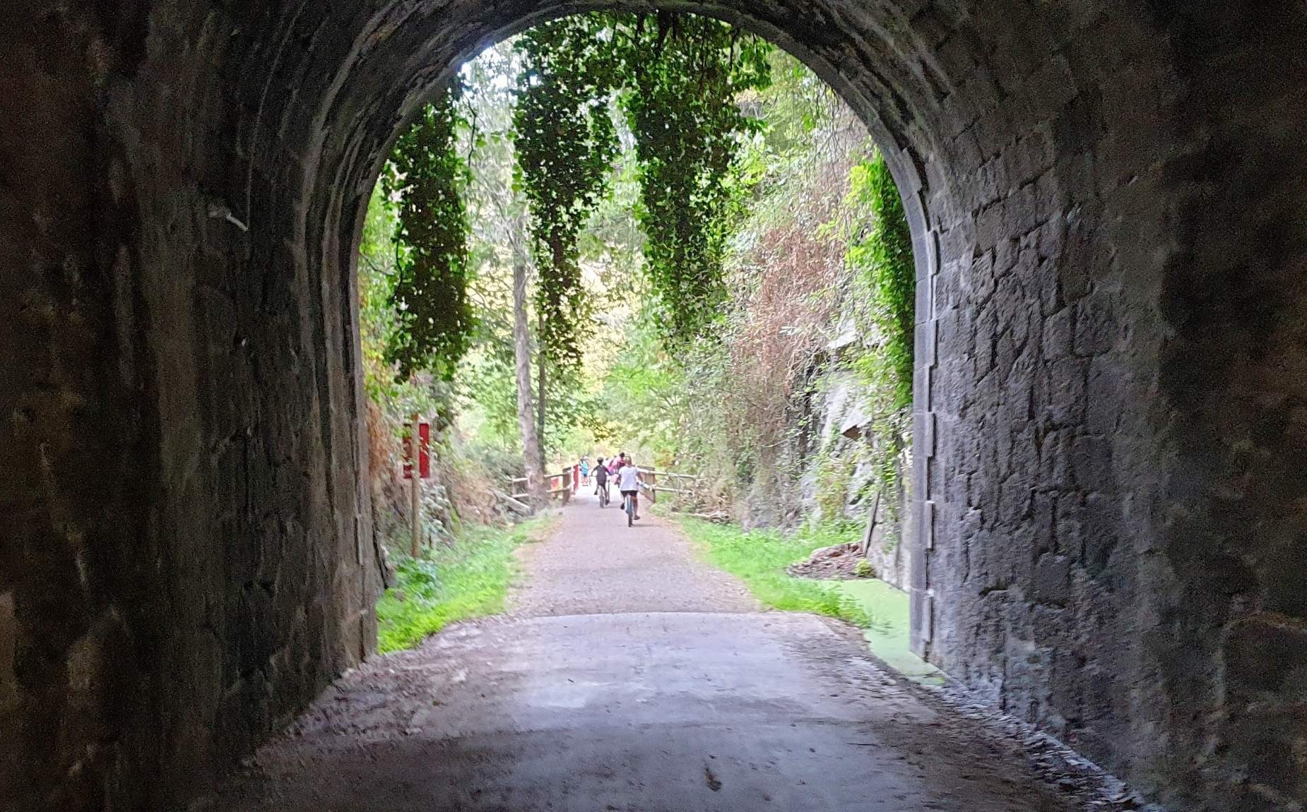 Tunel por debajo de una monta&ntilde;a con varios ni&ntilde;os en bicicleta