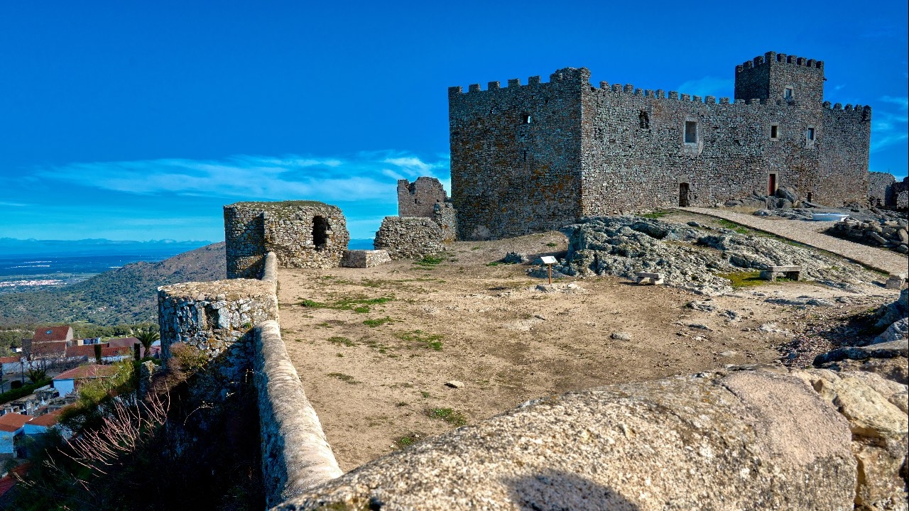 Perpectiva con el castillo de fondo y la muralla en primer plano.