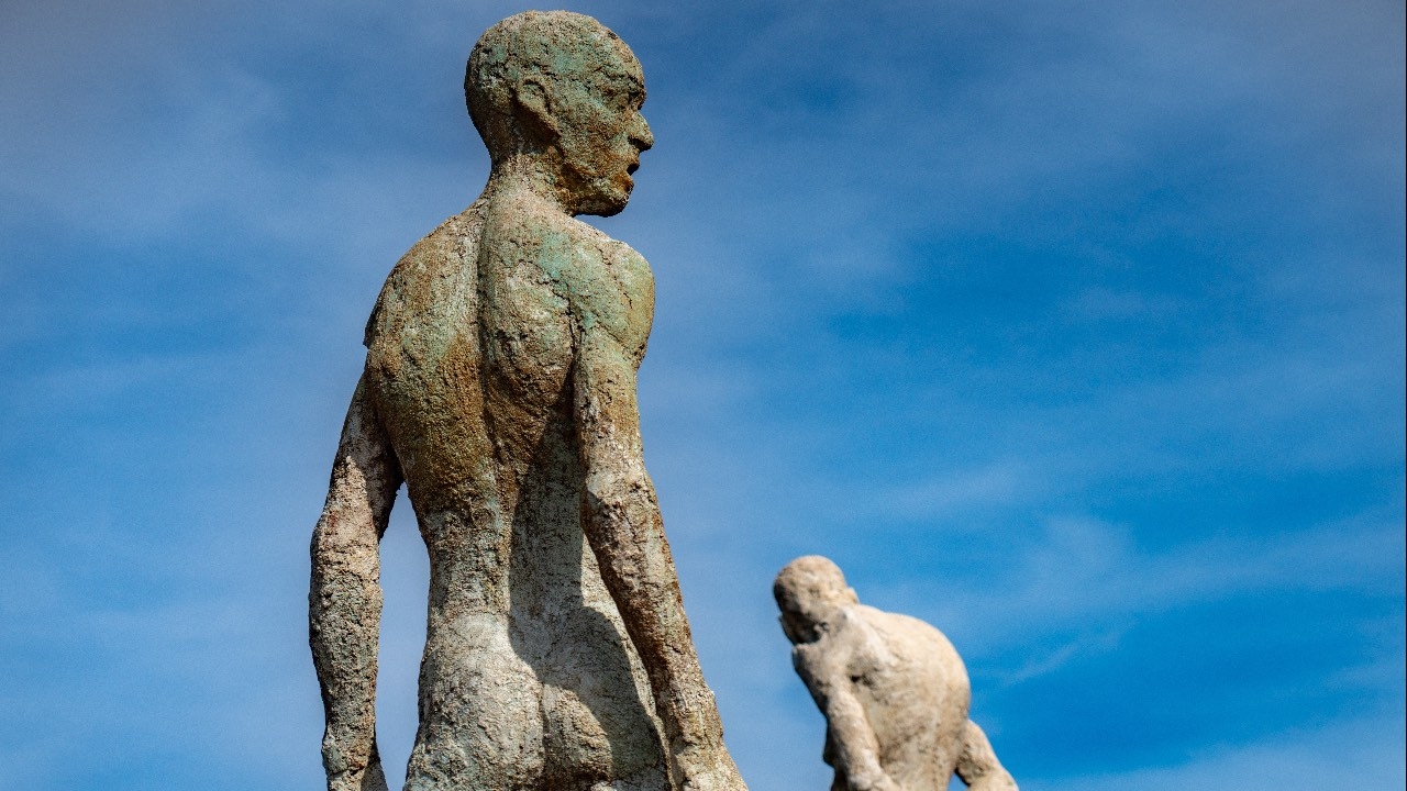 detalle de dos de las figuras contemplando el paisaje