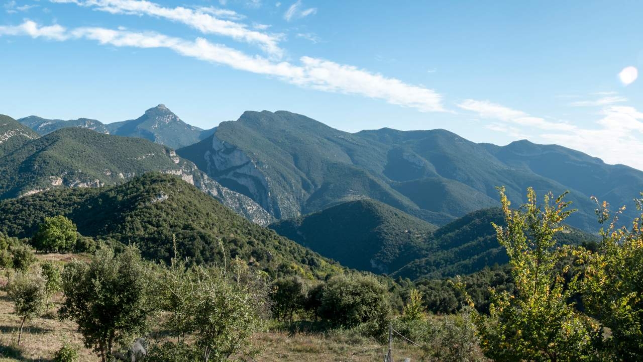 Mountainous area with peaks and vegetation.