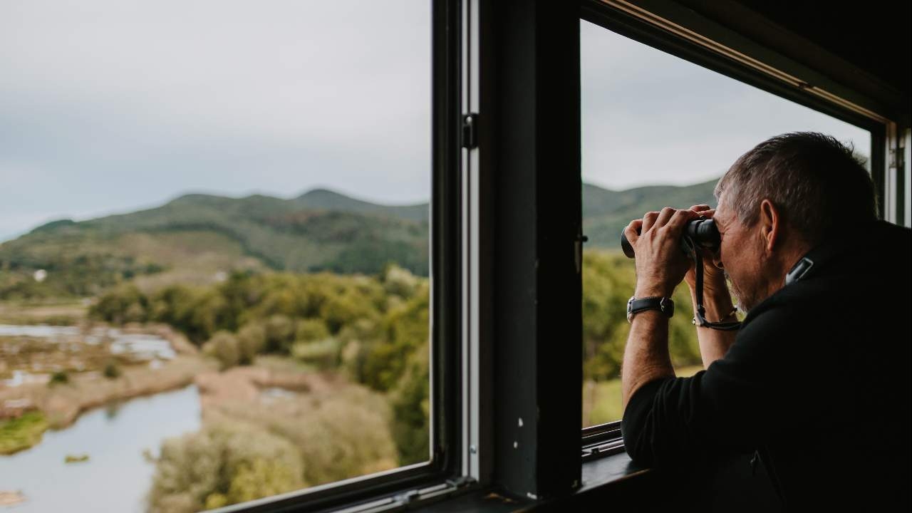 Person with binoculars looking at the Urdaibai landscape.