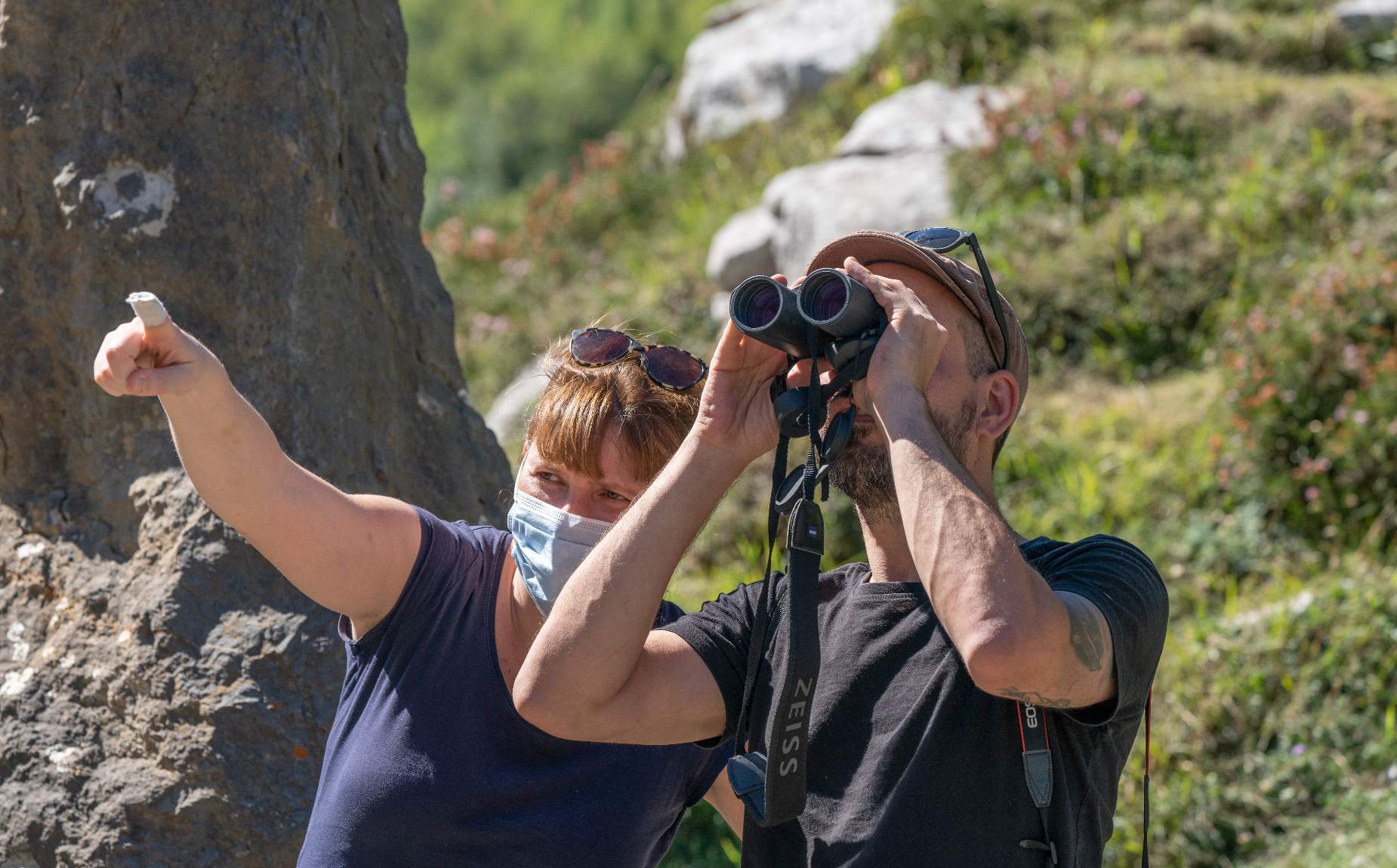 Two people observing through binoculars.