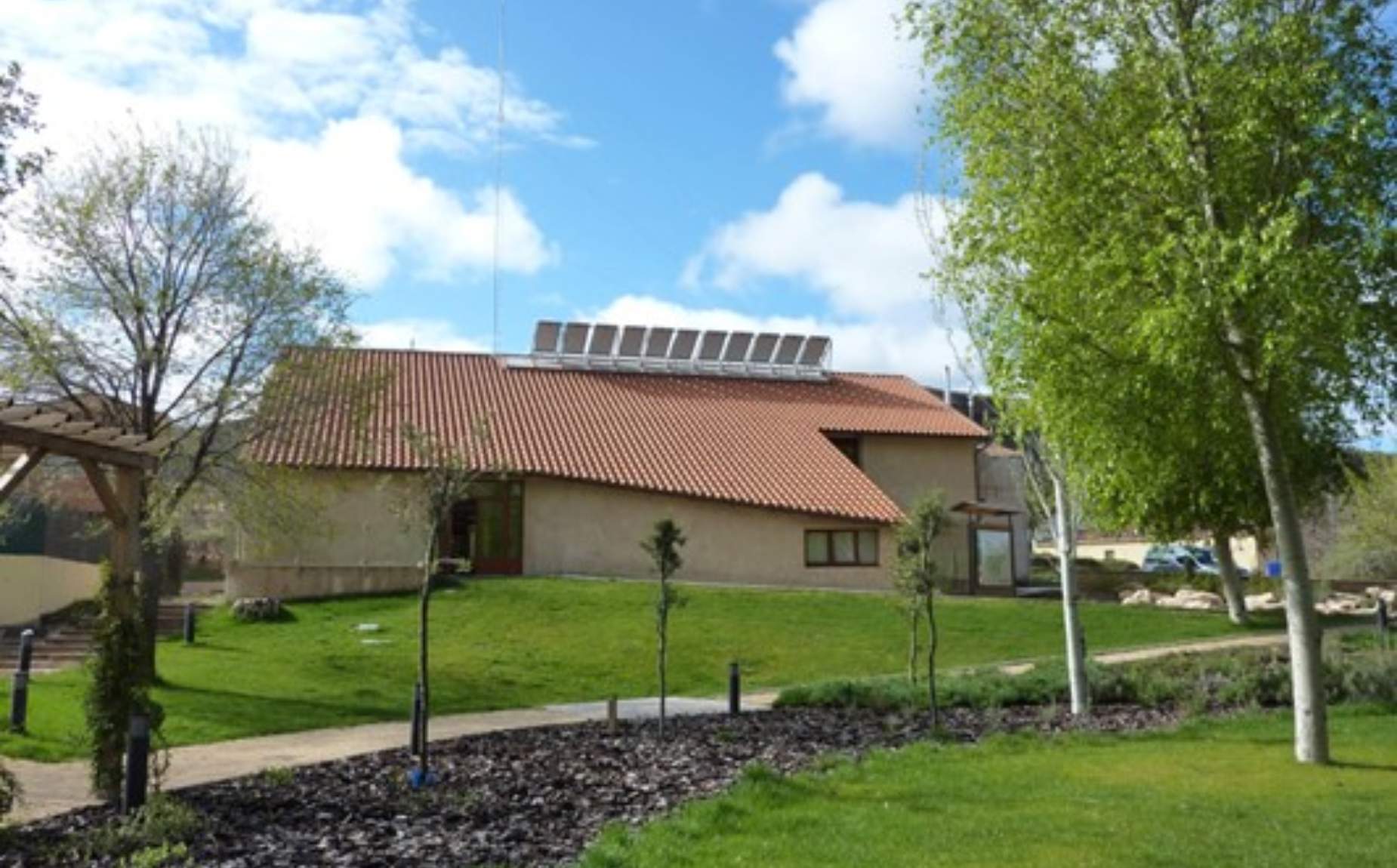 Una casa rural con placas solares en el tejado.