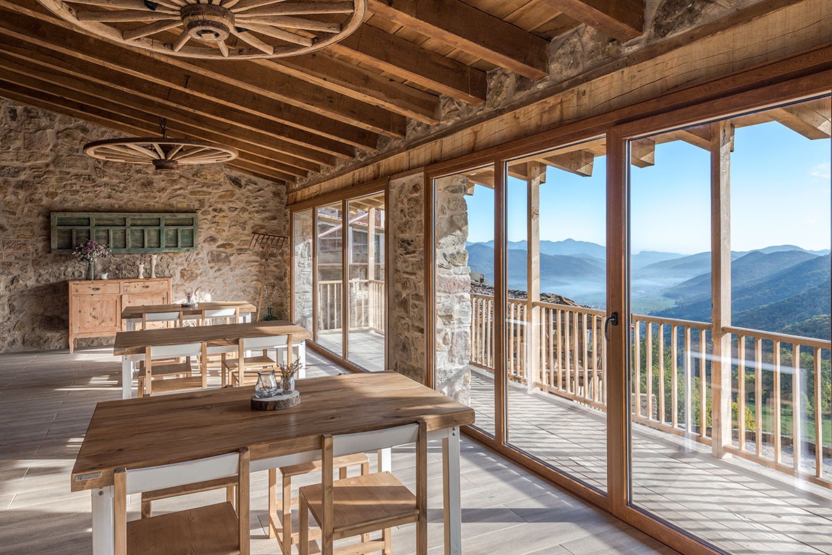 Sala de comidas con un ventanal con vistas a las montanas