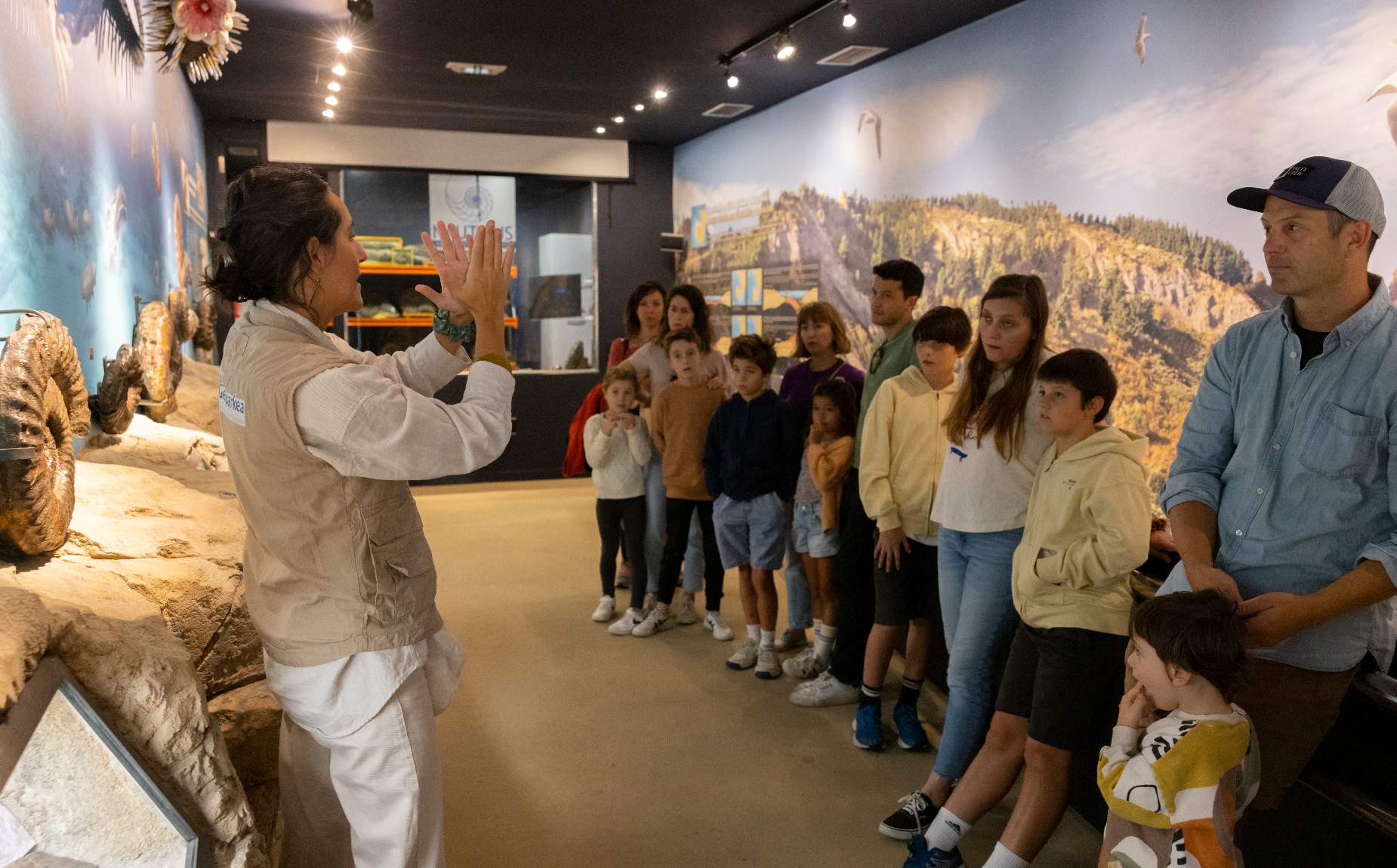 Guia explicando fosiles en el museo a varias personas