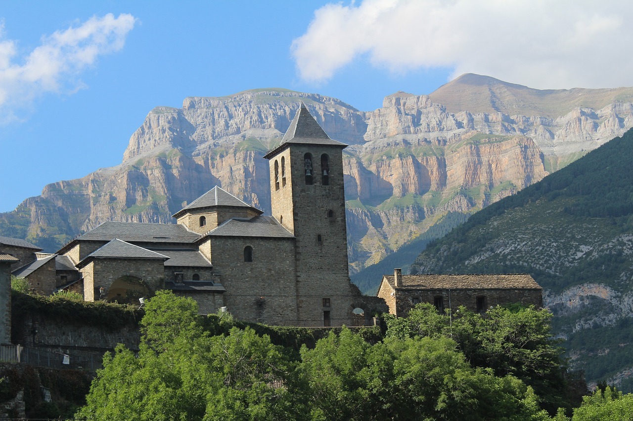 Iglesia encima de una colina con diferentes montanas a lo lejos