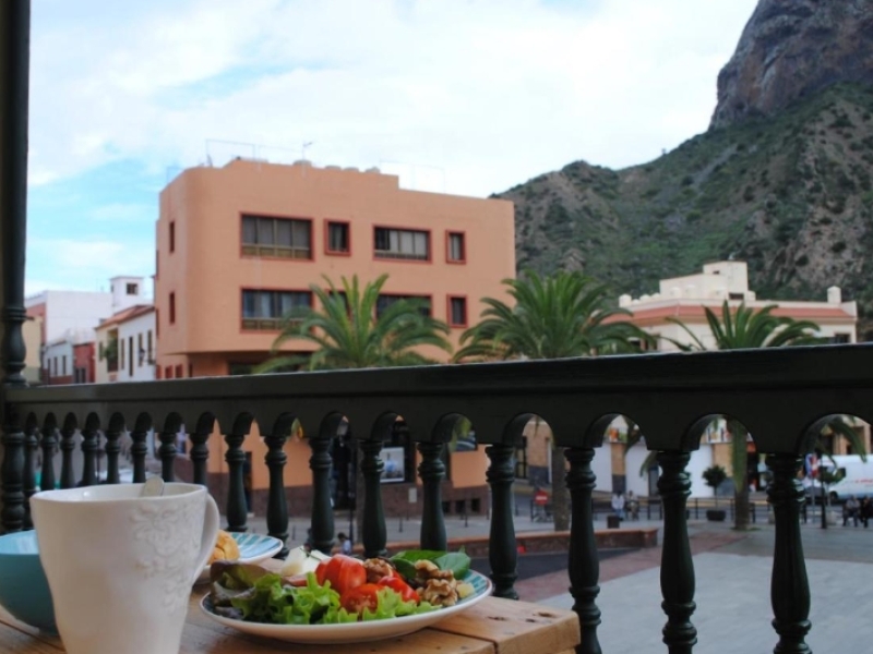 plato de comida y taza encima de una mesa en el balcón con vistas a una montaña