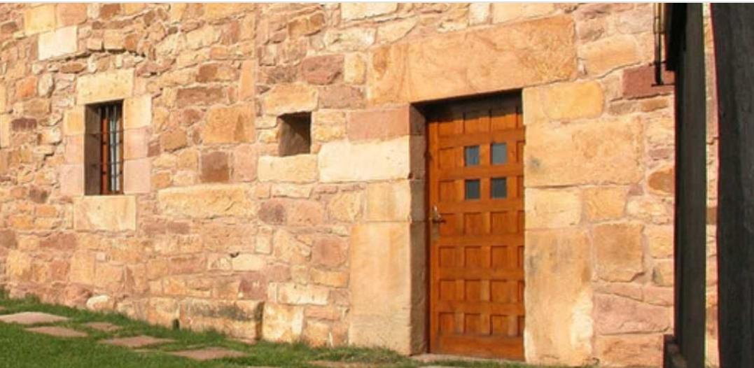 Fachada de piedra con una puerta de madera 